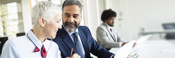 Asesoramiento Patrimonial - Dos personas de negocios con traje contentos trabajando juntos en la oficina Asesoramiento Patrimonial - Dos personas de negocios con traje contentos trabajando juntos en la oficina