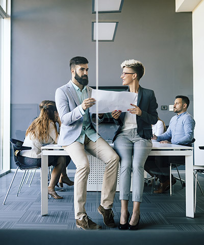 Ventajas para empresas - Dos personas de traje hablando sentados en una sala de reuniones en la oficina Ventajas para empresas - Dos personas de traje hablando sentados en una sala de reuniones en la oficina