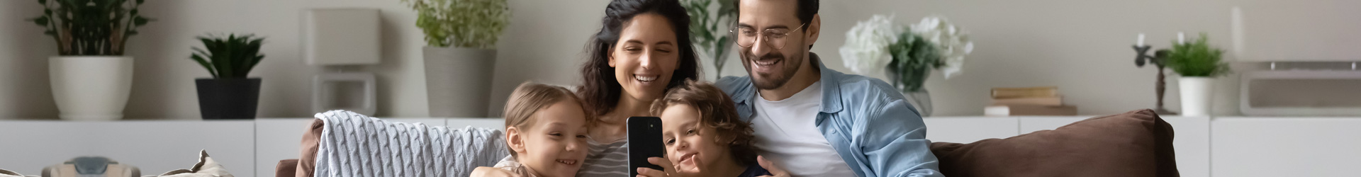 Calcula tu ahorro con el Plan Disfruta Seguro de Caja Rural del Sur - Una familia contrata un seguro sentados en el sofá de su casa felices